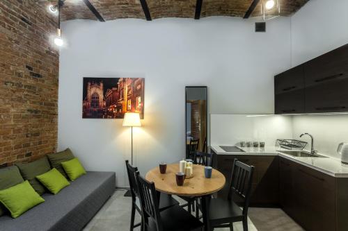 a kitchen and living room with a couch and a table at Apartamenty Centrum Częstochowa Stara Kamienica in Częstochowa