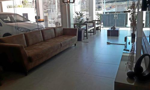 sala de estar con sofá marrón y mesa en Hotel Sempre Executive, en Salvador