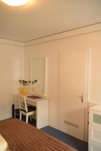 a bedroom with a desk and a bed and a mirror at Landhotel Röfleuten in Pfronten