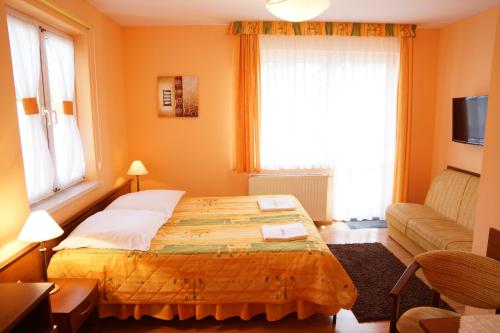 a bedroom with a bed and a couch and a window at Willa Grażyna in Ustroń