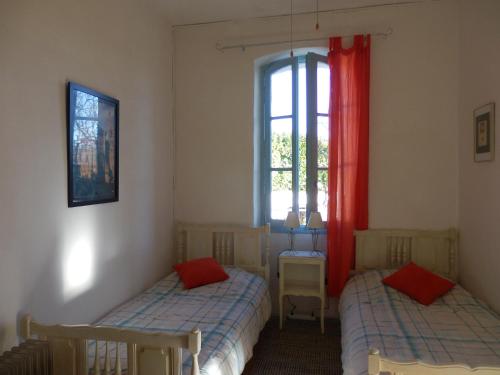 two beds in a room with a window at The Railway Cottage at Montazels in Espéraza