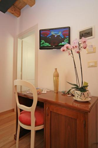 a desk with a chair and a vase with flowers on it at Locanda Al Ponte de Fero in Jesolo