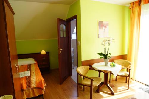 a room with green walls and a table and chairs at Willa Grażyna in Ustroń