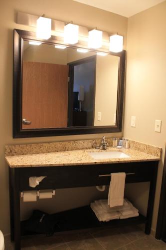 łazienka z umywalką i dużym lustrem w obiekcie Brookstone Lodge & Suites - Emmetsburg w mieście Emmetsburg