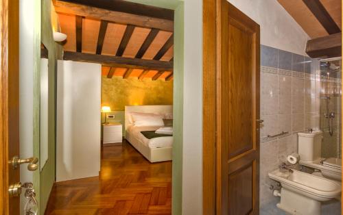 a bathroom with a bed and a toilet in a room at Villa Martina Classic & Luxury Room in Pisa