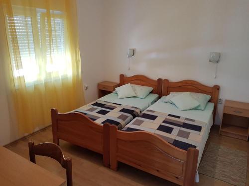 two twin beds in a room with a window at Apartments Polic with Terrace in Baška