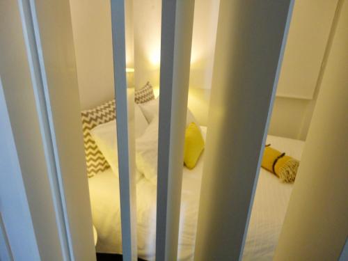 vista su una camera da letto con lenzuola bianche e cuscini gialli di Tarik Moments Apartment a Portimão