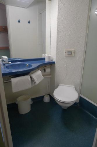 a bathroom with a blue sink and a toilet at ibis budget Narbonne Sud A9/A61 in Narbonne