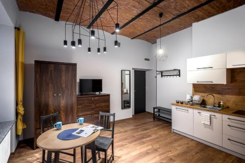 a kitchen and dining room with a table and chairs at Apartamenty Centrum Częstochowa Stara Kamienica in Częstochowa