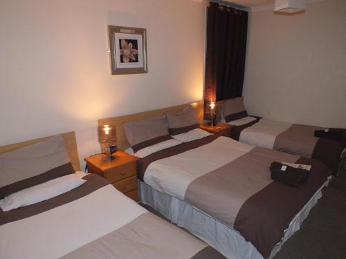 A bed or beds in a room at Marina Inn 