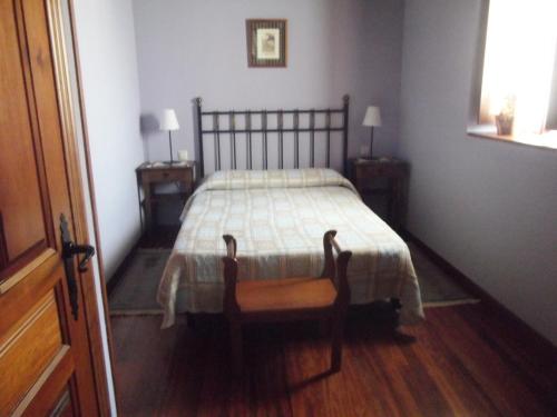 ein Schlafzimmer mit einem Bett und einem Stuhl darin in der Unterkunft La Canaleja in Cigüenza