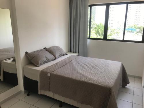 a bedroom with a bed and a window at Flat Parque Jaqueira Home Service in Recife