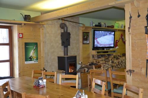 a dining room with a fireplace and a television at Apartmán v Srdci Hor Cihlářka in Pec pod Sněžkou