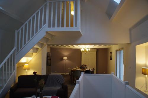 a living room with a staircase and a dining room at La Cour Royale in Bayeux