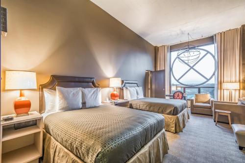 a hotel room with two beds and a window at Proximity Hotel in Greensboro