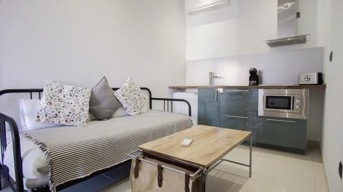 a kitchen with a table and a microwave at The Lights Suites in Málaga