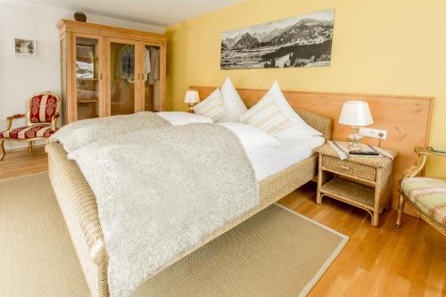 a bedroom with a large bed and a chair at Louisa in Oberstdorf