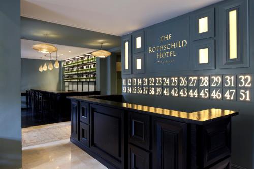 a bar in a restaurant with a sign on the wall at The Rothschild Hotel - Tel Aviv's Finest in Tel Aviv