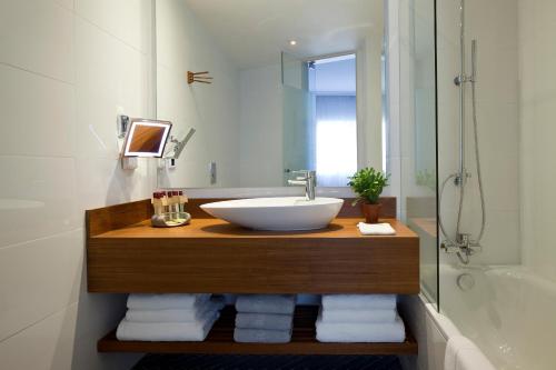 uma casa de banho com um lavatório, um chuveiro e uma banheira em The Rothschild Hotel - Tel Aviv's Finest em Tel Aviv
