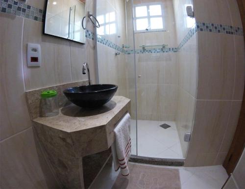 a bathroom with a sink and a shower at Pousada Belafonte Riocentro in Rio de Janeiro