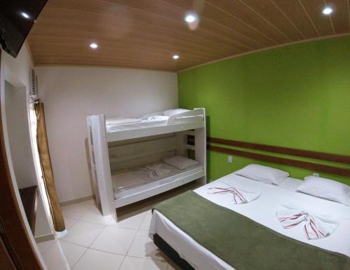 two beds in a room with green walls at Pousada Belafonte Riocentro in Rio de Janeiro