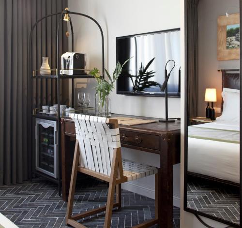 a bedroom with a desk and a bed and a bed and a mirror at The Rothschild Hotel - Tel Aviv's Finest in Tel Aviv