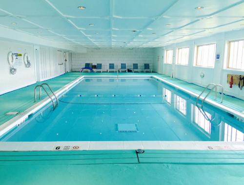 uma grande piscina interior com água azul em Ocean Vista Resort em Amagansett