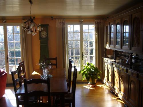 une salle à manger avec une table et une horloge au mur dans l'établissement Chambres d'hôtes Al Camp d'Espalougues, à Ur