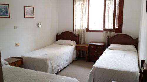 una habitación con dos camas y una ventana en el Hotel Bamba de Villa Gesell