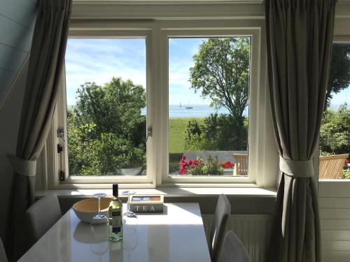 a room with a table and a window with a view at Slapen aan het IJsselmeer - with SEAVIEW and SUNSET in Stavoren