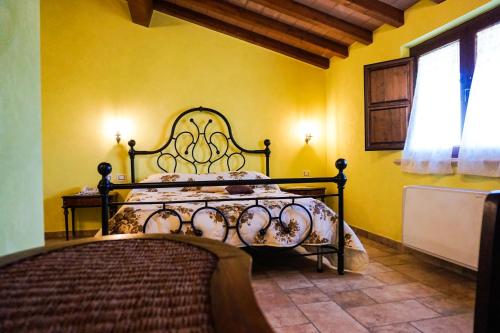 1 dormitorio con 1 cama en una pared amarilla en La Tenuta del Campo di Sopra, en Patrica