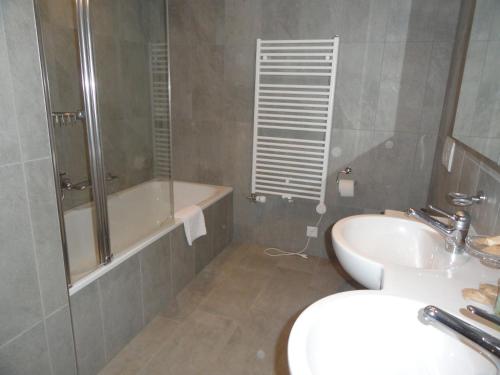 ヴェンゲンにあるChalet Bella Vista 6のバスルーム(シャワー、シンク、バスタブ付)