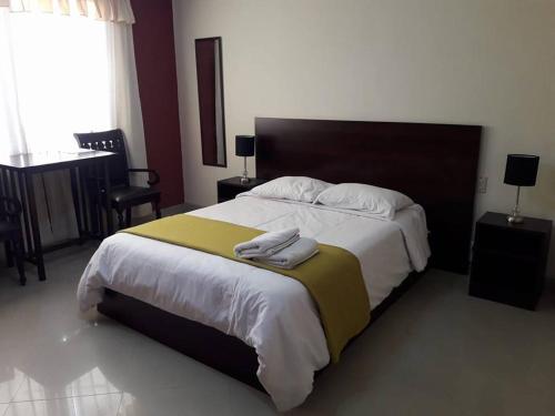 a bedroom with a large bed with two towels on it at Le Saint-Etienne in Trujillo