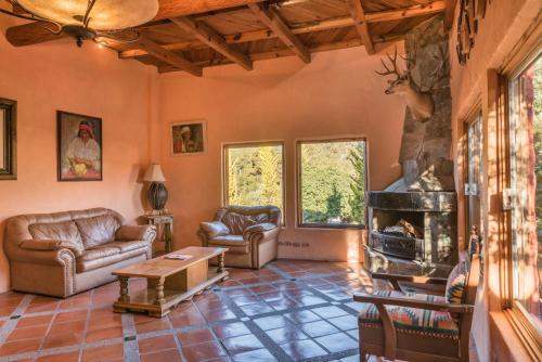 a living room with couches and a fireplace at Hotel Barrancas del Cobre a Balderrama Hotel Collection in Areponapuchi