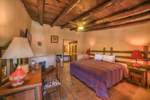 a bedroom with a bed and a table with a lamp at Hotel Barrancas del Cobre a Balderrama Hotel Collection in Areponapuchi