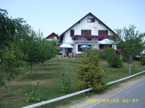 a white house with trees and bushes in front of it at Guest House Adrijana in Seliste Dreznicko