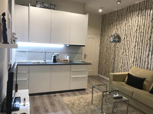 マドリードにあるApartamento Gran Via Callaoの白いキャビネットとソファ付きのキッチンが備わります。