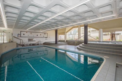 a large swimming pool in a building at Surfers Aquarius on the Beach in Gold Coast