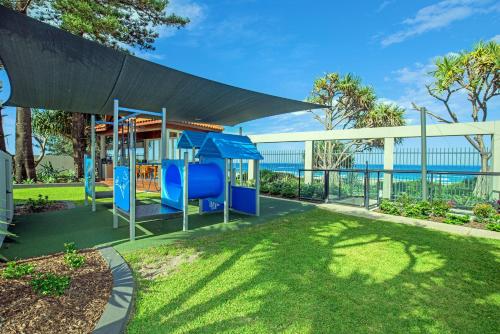 a playground in a park with the ocean in the background at Surfers Aquarius on the Beach in Gold Coast