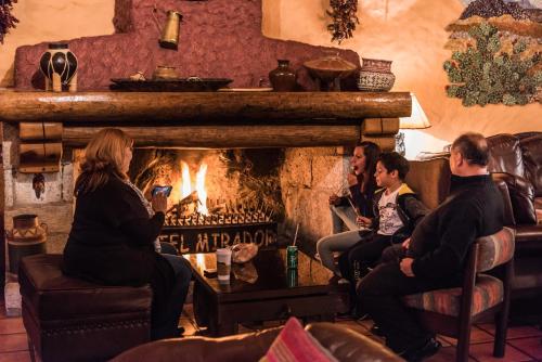people sitting around a fire place at Hotel El Mirador a Balderrama Collection Hotel in Areponapuchi