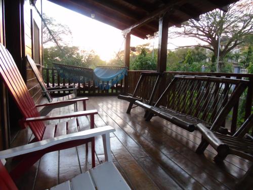 a group of benches sitting on a porch at Hostal Villas Mexico in San Juan del Sur