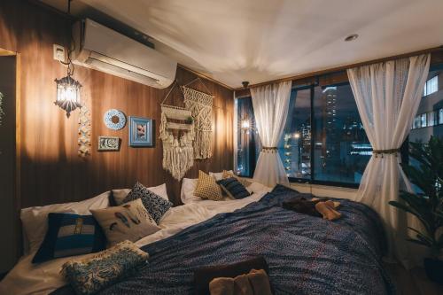 a bedroom with a large bed in front of a window at Aqua cite KITAHAMA in Osaka