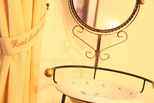 a mirror and a chair in front of a curtain at Hotel Resort Nuraghe Arvu in Cala Gonone
