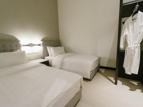 a hotel room with two beds and a mirror at Avillion Cameron Highlands in Cameron Highlands