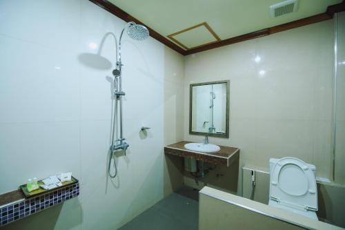 a bathroom with a sink and a toilet and a mirror at AmornSukhothai Hotel in Sukhothai