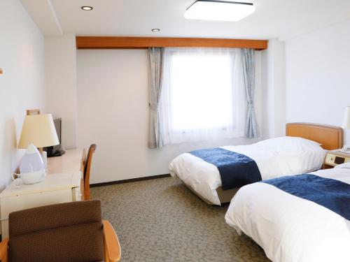 a hotel room with two beds and a window at Gran Hotel in Shingu