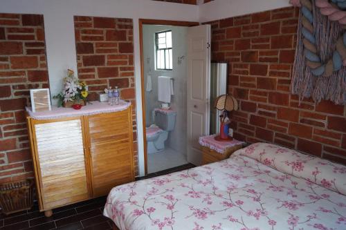 a bedroom with a bed and a brick wall at Hotel Casa de la Luna in San Juan Teotihuacán