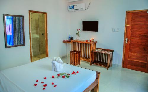 ein Zimmer mit einem Tisch mit roten Blumen darauf in der Unterkunft Christima Residence in Negombo