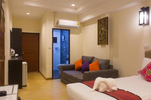 ein Wohnzimmer mit einem Sofa, einem Sofa und einem Stuhl in der Unterkunft Suan Dok Gate Guesthouse in Chiang Mai