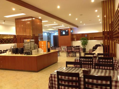 Motel Xiamen Railway Station في شيامن: مطعم بطاولات وكراسي وكاونتر